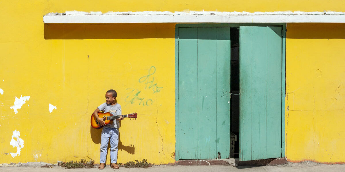 imb-photos-20081201mp0403-small An orphan at the Orfanato Niños de Cristo in La Romana, Dominican Republic poses with his guitar after music lessons.